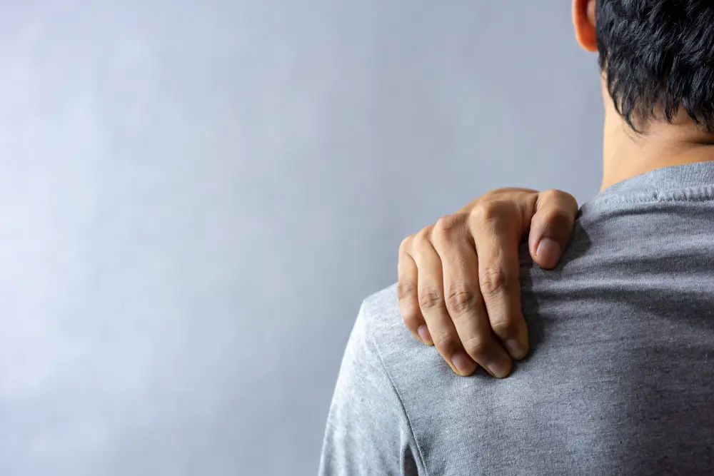 man holding his shoulder from pain